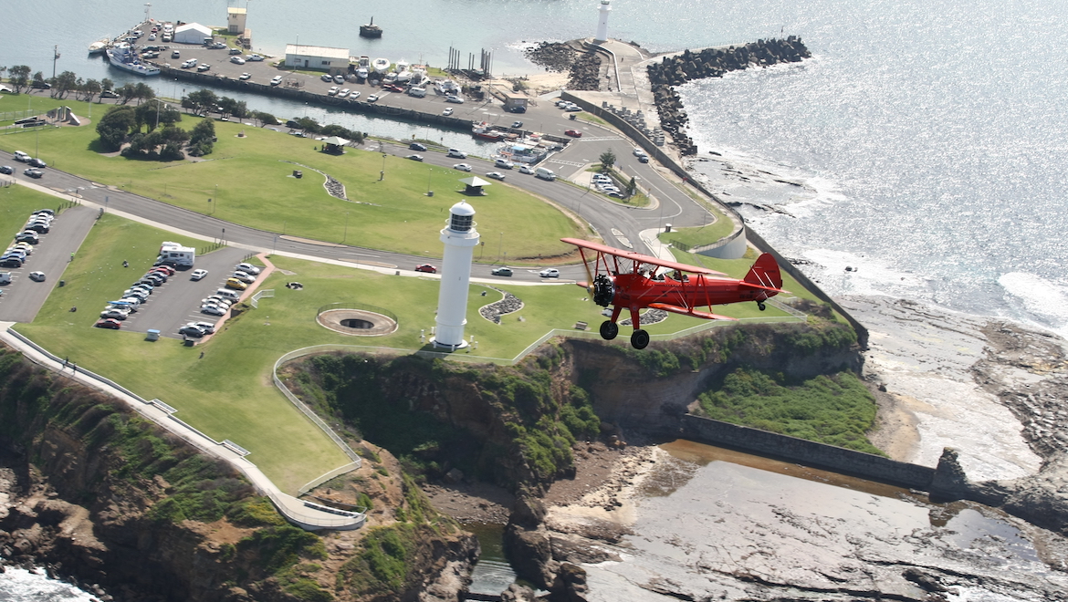 VH-ILW flies past Wollongong’s Breakwater Lighthouse. (Nicholas Eccles)